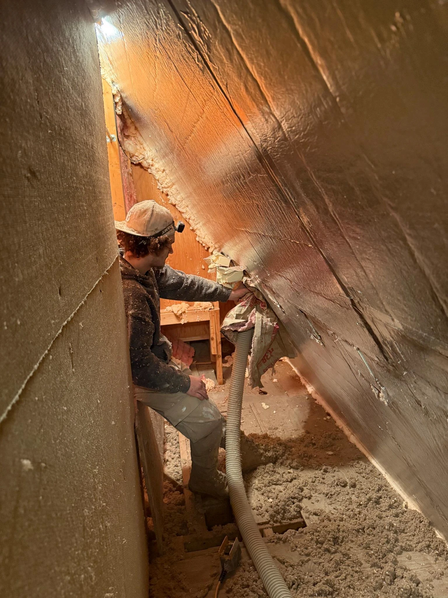 McMahon Insulation installer blowing cellulose insulation across an attic floor